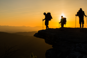 Silhouette of hikers atop McAfee Knob at sunset.