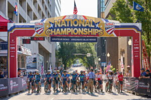 Road cyclists pose under USAC Championship sign