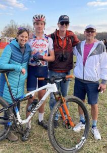 Henry Schumm, local teen cyclist, poses with family and coaches after bike race.