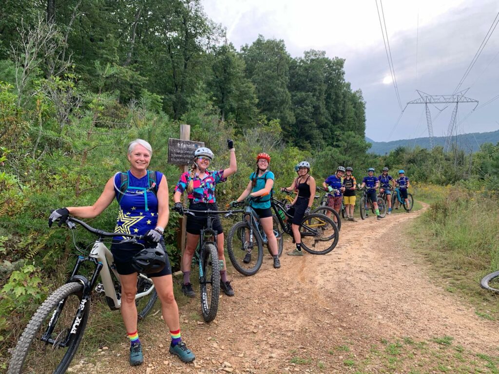 Group of women cyclists pause a mountain bike ride to smile for the camera